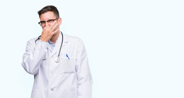 Handsome Young Doctor Man Smelling Something Stinky Disgusting Intolerable Smell — Stock Photo, Image
