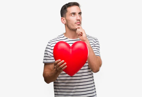 Handsome Young Man Love Holding Red Heart Serious Face Thinking — Stock Photo, Image