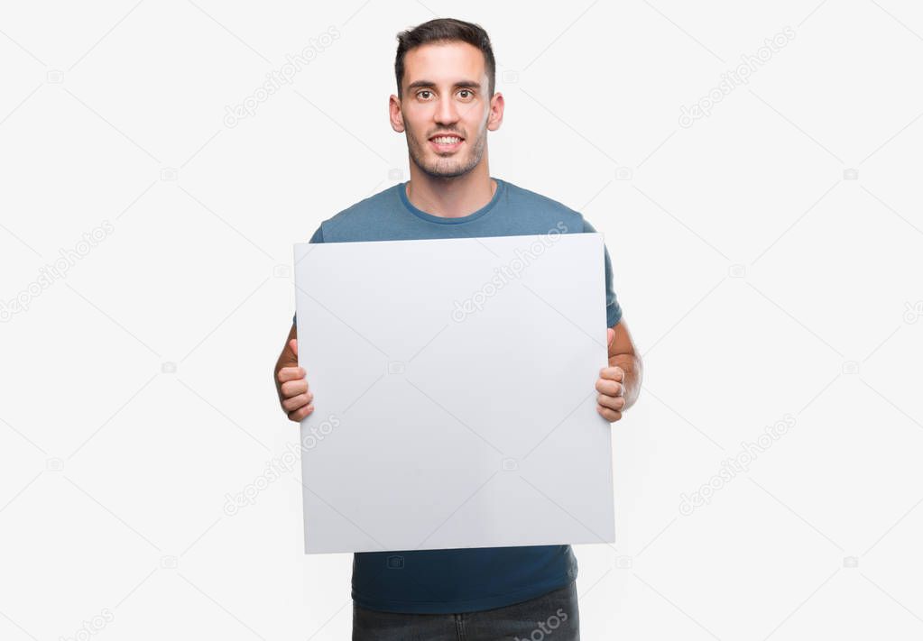 Handsome young man holding advertising banner with a happy face standing and smiling with a confident smile showing teeth
