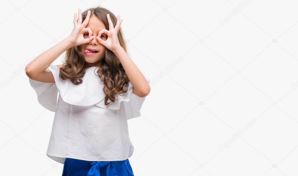 Brunette hispanic girl doing ok gesture like binoculars sticking tongue out, eyes looking through fingers. Crazy expression.