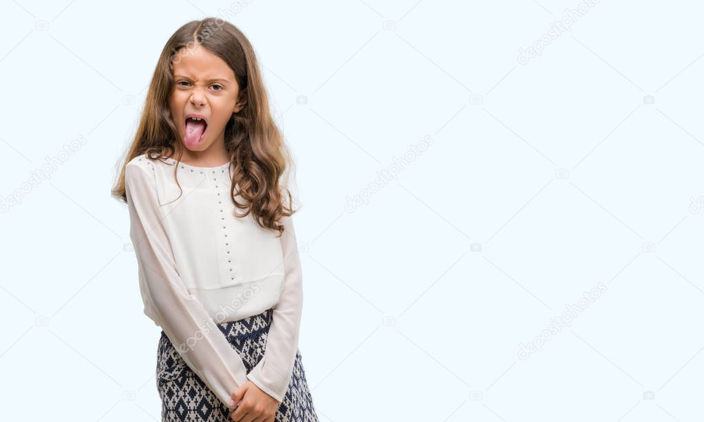 Brunette hispanic girl sticking tongue out happy with funny expression. Emotion concept.