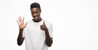 Gösterilen ve parmakları ile işaret beyaz t-shirt giyen genç Afro-Amerikan adam kendinden emin ve mutlu gülümseyerek süre 6 numara.