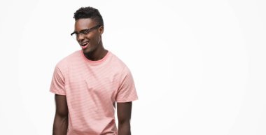 Pembe tişört göz kırpıyor seksi bir ifadeyle, neşeli ve mutlu yüzünü kameraya bakarak giyen genç Afro-Amerikan adam.