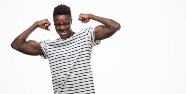 Gözlük ve deniz kuvvetleri t-shirt gösteren giyen genç Afro-Amerikan adam gururlu gülümseyen kas silah. Fitness kavramı.