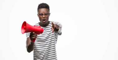 Kameraya parmak ile işaret megafon ve, el işareti, pozitif ve kendinden emin bir jest önden tutan genç Afro-Amerikan adam