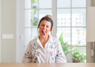 Genç kadına ev yapışma dil out komik ifade ile mutlu. Duygu kavramı.