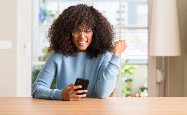 Duygu tezahürat gurur çığlık ve zafer ve başarı çok heyecanlı, kutluyor smartphone kullanan güzel Afrikalı-Amerikalı kadın