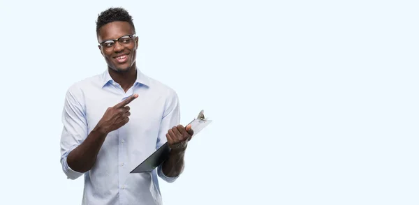 Joven Hombre Afroamericano Sosteniendo Clipboarad Muy Feliz Señalando Con Mano — Foto de Stock