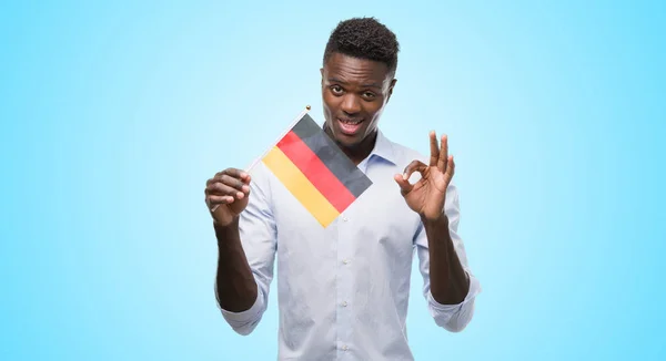 Joven Hombre Afroamericano Sosteniendo Bandera Alemana Haciendo Signo Con Los —  Fotos de Stock