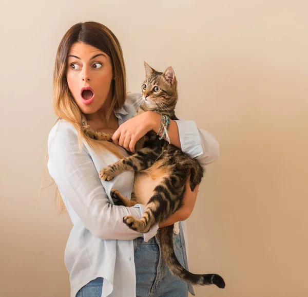 若くてきれいな女性が自宅で愛と驚き顔抱きしめる猫とショックを受けた — ストック写真