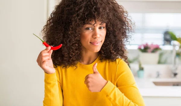 非洲裔美国妇女吃红辣椒高兴与大微笑做 拇指与手指 优秀的标志 — 图库照片