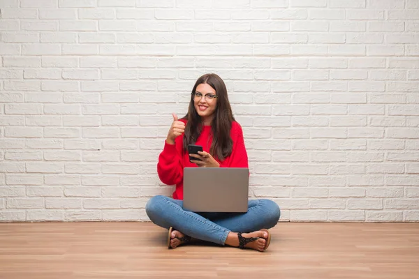 Mujer Morena Joven Sentada Suelo Usando Ordenador Portátil Teléfono Inteligente —  Fotos de Stock