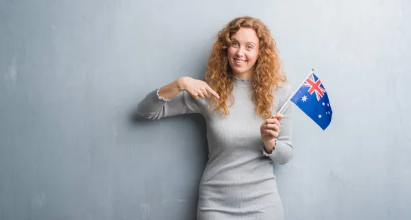 Joven Pelirroja Sobre Pared Grunge Gris Sosteniendo Bandera Australia Con —  Fotos de Stock