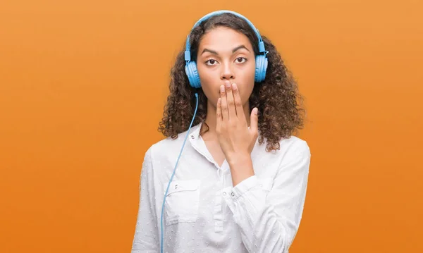 Junge Hispanische Frau Mit Kopfhörer Bedeckt Mund Mit Hand Schockiert — Stockfoto