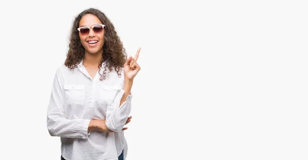 Jovem Hispânica Usando Óculos Sol Muito Feliz Apontando Com Mão — Fotografia de Stock