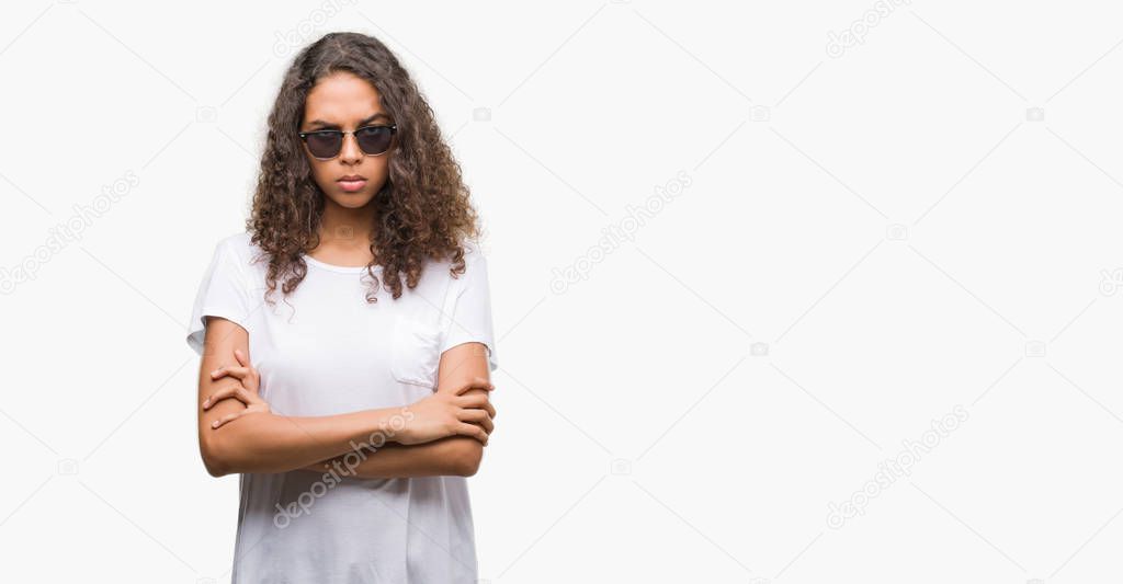 Young hispanic woman wearing sunglasses skeptic and nervous, disapproving expression on face with crossed arms. Negative person.