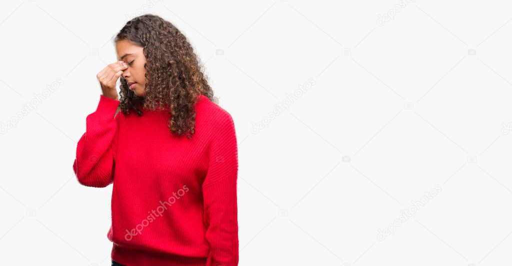 Young hispanic woman wearing red sweater tired rubbing nose and eyes feeling fatigue and headache. Stress and frustration concept.