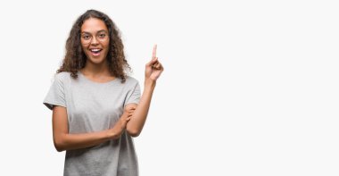 Kameraya bakarak yan el ve parmak ile işaret gözlüklü kocaman bir gülümseme ile yüzünde, güzel genç İspanyol kadın.