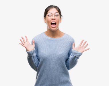 Kocaman bir gülümseme ile çığlık zaferini kutluyor ve ellerini kaldırdı bir topuz çok mutlu ve heyecanlı, kazanan ifade giyen genç güzel İspanyol kadın