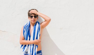 Tatil günlerinde elle kafasına, stresli bir donanma havlu giyen genç çocuk şok utanç ve sürpriz suratla, öfkeli ve sinirli. Korku ve hata için üzgün.