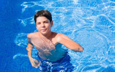Tatil günlerinde genç çocuk kendisi için sürpriz yüz işaret parmağı plajda yüzme havuzunda