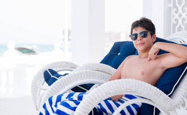 Tatil günlerinde sürpriz yüz işaret parmağı kendisine sandalye üzerinde oturan genç çocuk