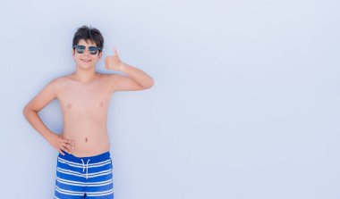 Ok işareti, başparmak ile parmak, mükemmel işareti yapıyor kocaman bir gülümseme ile mutlu duvardan ayakta tatil günlerinde genç çocuk