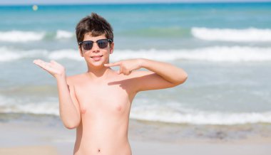 Sahilde el ve parmak ile işaret çok mutlu tatil günlerinde genç çocuk