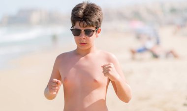 Genç çocuk tatil sahilde rahatsız ve boşa çıkarmak ile öfke, çılgın ve yükseltilmiş eliyle diye bağıran öfke kavramı bağırarak.