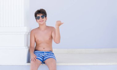 İşaret ve başparmak kadar mutlu yüz gülümseyen tarafı ile gösterilen tatil günlerinde genç çocuk