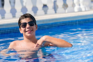 Kendisi için sürpriz yüz işaret parmağı plajda yüzme havuzunda genç çocuk tatilde
