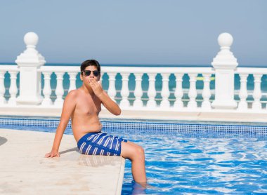 Sessizlik, gizli kavramı tatil beach kapak Ağızdan El için hata, ifade korku, utanç ile şok ile yüzme havuzunda genç çocuk korkuttu