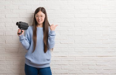 Holding video kamera işaret ve başparmak kadar mutlu yüz gülümseyen tarafı ile gösterilen filme Genç Çinli kadın