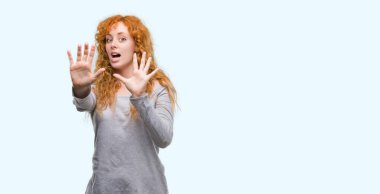 Genç Kızıl saçlı kadın korkuyor ve korku ifade dur hareketi el ile ile dehşete şokta bağırarak. Panik kavramı.