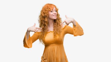 Yüzünde gülümseme ile kendinden emin görünüyorsun, kendini gururlu ve mutlu parmakları ile işaret genç Kızıl saçlı kadın.