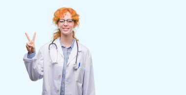 Genç redhead gösterilen ve parmakları ile işaret üniforma giyen doktor kadın ikincisi ise kendinden emin ve mutlu gülümseyerek.
