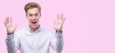 Genç yakışıklı sarışın adam çok mutlu ve heyecanlı, kazanan ifade büyük gülümseme ile çığlık ve ellerini kaldırdı zaferini kutluyor