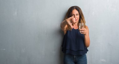 Orta yaş İspanyol kadın kızgın yüzü, eksi işareti aşağı antipati başparmak ile gösterilen, ret kavramı ile su içme