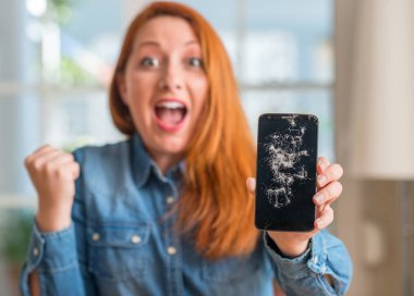 Duygu tezahürat gurur çığlık ve zafer ve başarı çok heyecanlı, kutluyor kırık smartphone tutan Kızıl saçlı kadın
