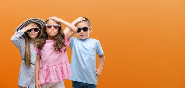 Grupy Dzieci Chłopca Dziewczyny Pomarańczowym Tle Podkreślił Ręki Głowie Wstrząśnięty — Zdjęcie stockowe