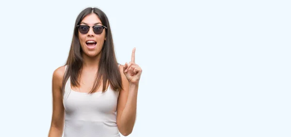 Junge Schöne Hispanische Mit Sonnenbrille Und Erhobenem Zeigefinger Mit Erfolgreicher — Stockfoto