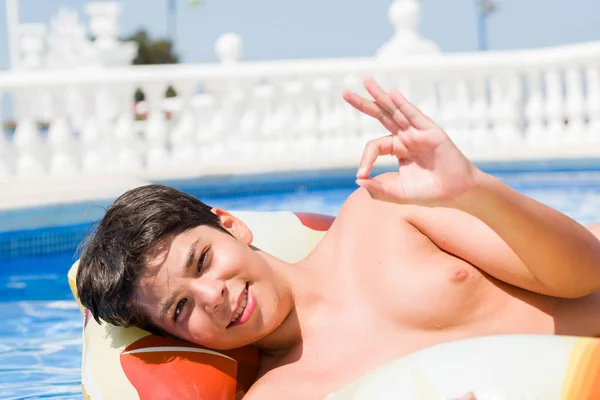 優秀なシンボルの指で サインをしているビーチでのスイミング プールで休日にパッドの若い子 — ストック写真
