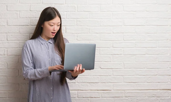 Молодая Китаянка Кирпичной Стеной Помощью Ноутбука Напуганный Шоке Неожиданным Лицом — стоковое фото