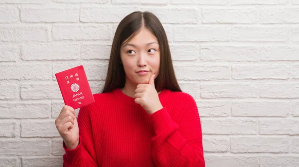 Joven Mujer China Sobre Pared Ladrillo Con Pasaporte Japón Cara —  Fotos de Stock