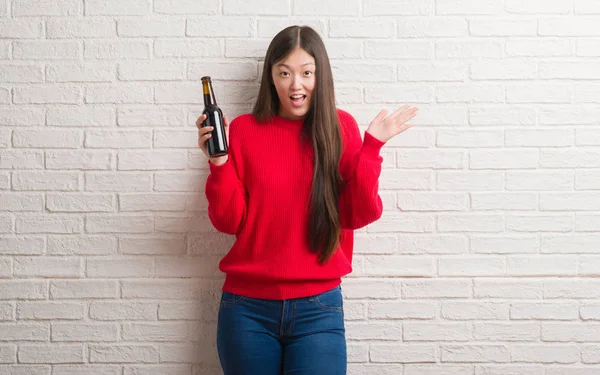Joven Mujer China Sobre Pared Ladrillo Bebiendo Cerveza Muy Feliz — Foto de Stock