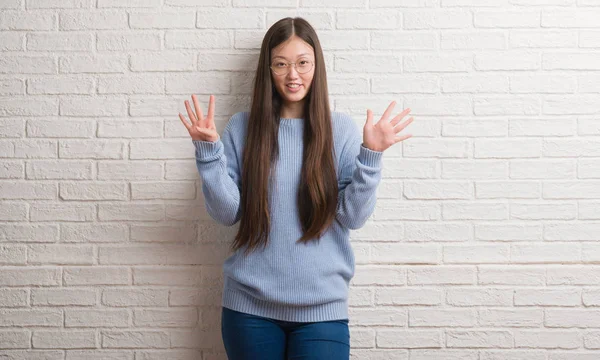 Chinise Mladá Žena Nad Bílou Cihlová Zeď Znázorňující Ukázal Prsty — Stock fotografie