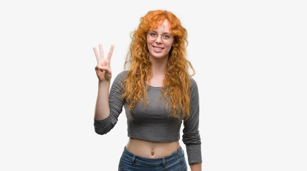 若い赤毛の女性の指で上向きの表示と番号自信を持って 幸せな笑みを浮かべている間 — ストック写真