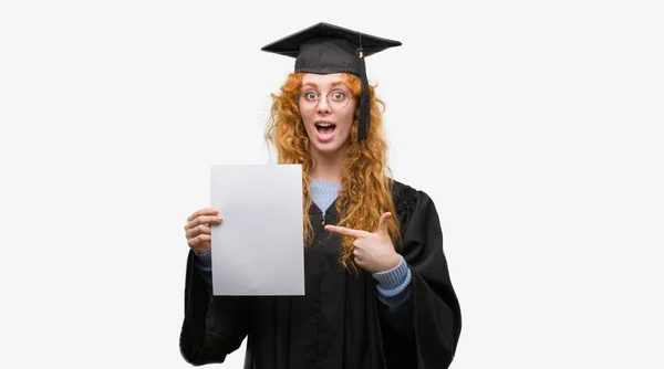 若い赤毛の女性の手と指で指している非常に満足度を保持している大学院の制服を着て — ストック写真