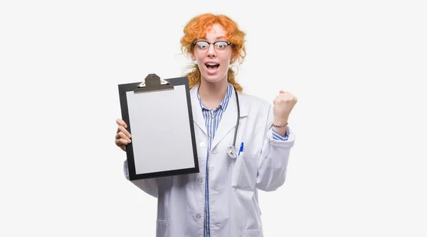 Giovane Rossa Medico Donna Tenendo Appunti Urlando Orgoglioso Celebrando Vittoria — Foto Stock