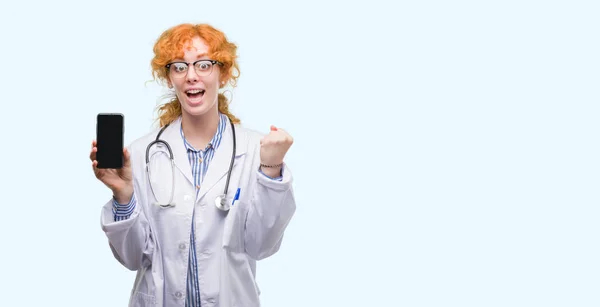 年轻红发医生的女人显示智能手机尖叫自豪和庆祝胜利和成功非常兴奋 欢呼的情绪 — 图库照片